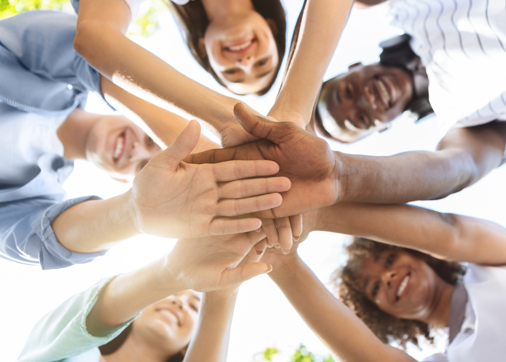 joukko nuoria seisoo kehässä ja lyö kätensä yhteen