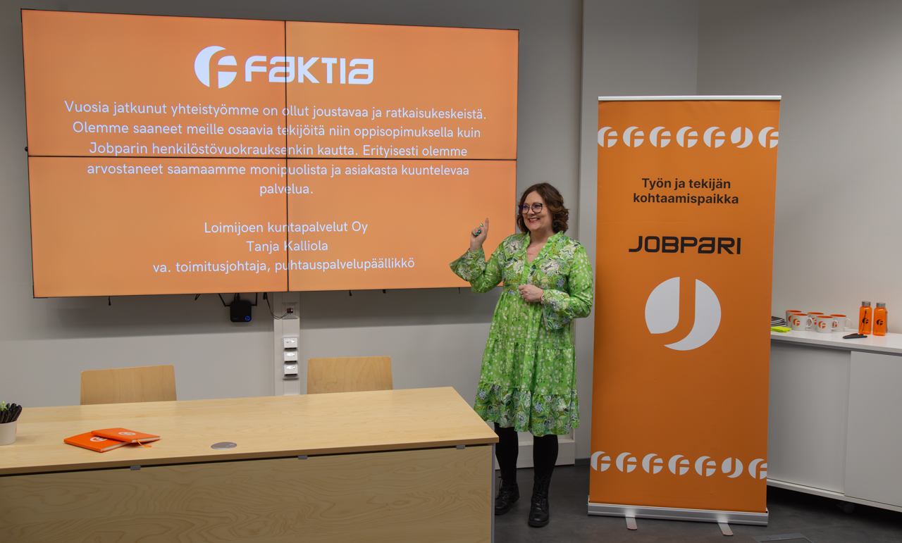 Hymyilevä nainen esittelee toimintaa