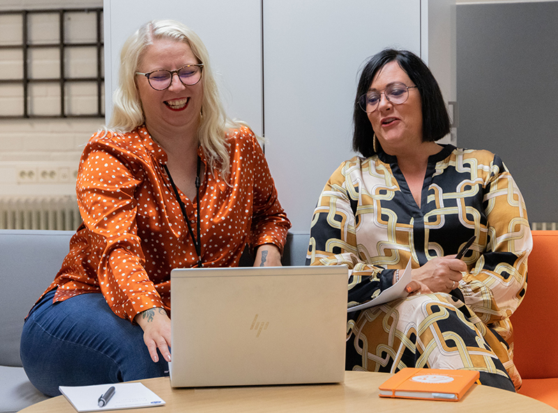Jobparin työntekijät Suvi Pelto-Knuutila ja Riikka Mäkinen istuvat sohvalla ja katsovat yhdessä tietokoneen näyttöä