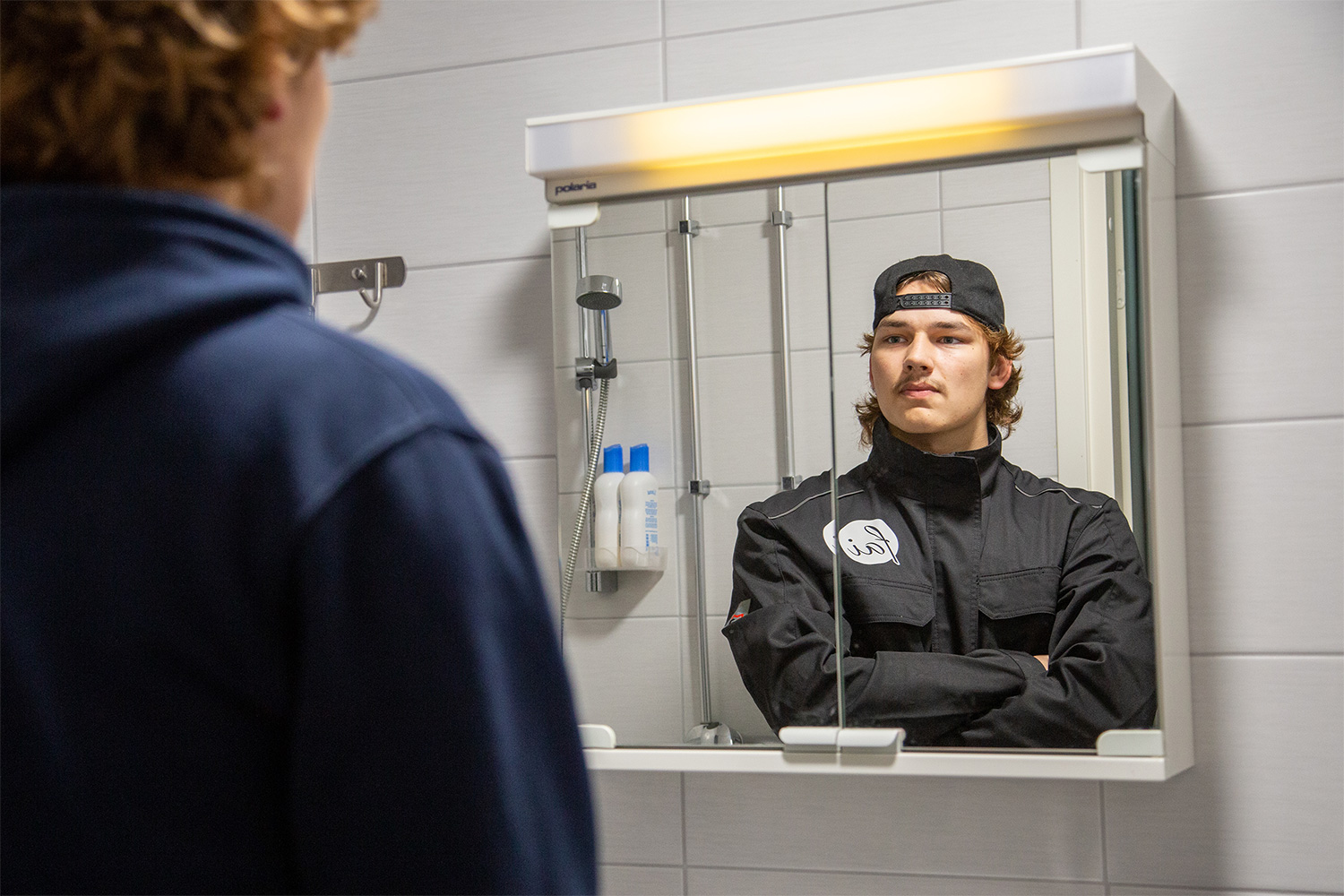 Nuori mies katsoo peilistä itseään ja näkee siellä itsensä erilaisena.