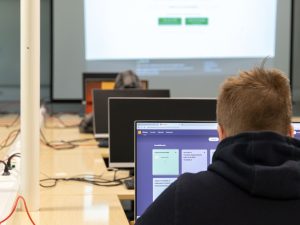 Tieto- ja viestintätekniikan opiskelija tekemässä tehtäviä tietokoneella