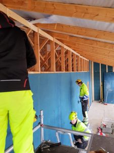 Rakennuspuolen opiskelijat talotyömaalla tekemässä väliseiniä