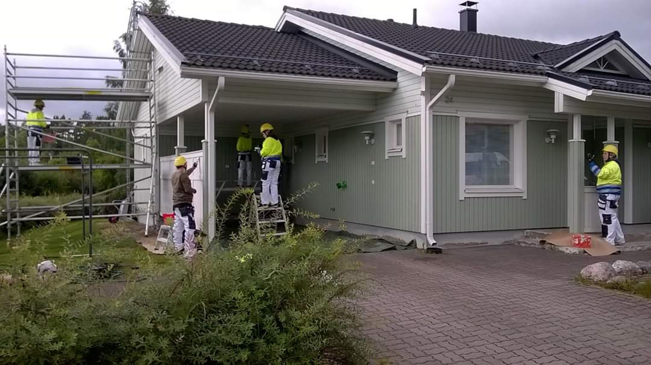 Pintapuolen opiskelijat maalamassa talon ulkovuorta