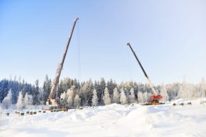 Kaksi ajoneuvonosturia talvisessa maisemassa